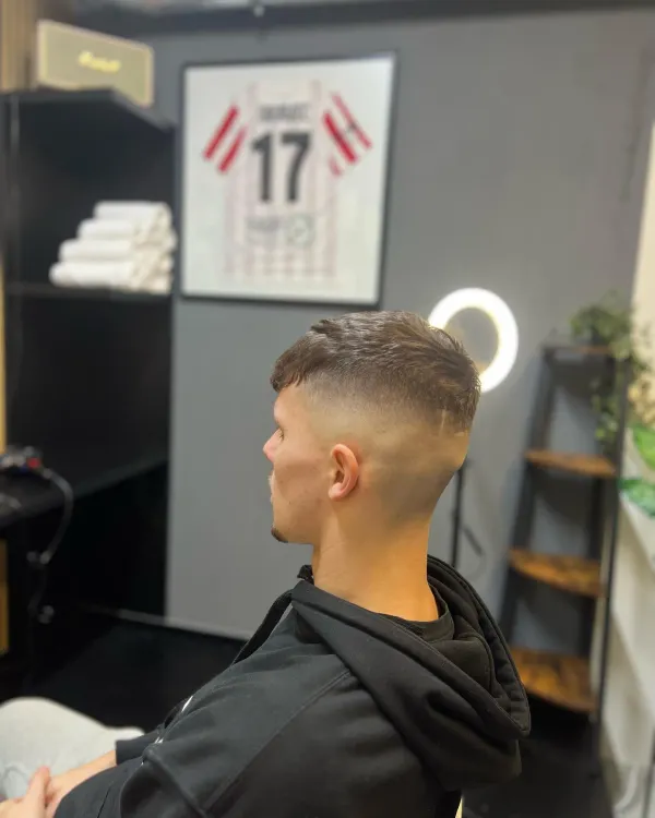 Precizní pánské stínování typu mid fade s texturou na vrchu hlavy od barbera v Dobřanech.