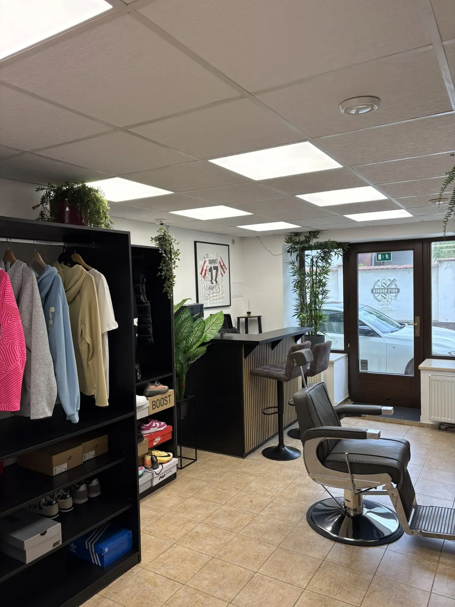 Vstupní prostor a věšák pro klienty v Ori's Barber Shopu.