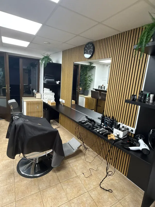 Interiér pánského holičství Ori's Barber Shop se stylovým barberským zázemím.