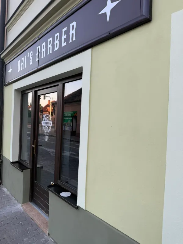 Pohled na exteriér Ori's Barber Shop z protější strany ulice v Dobřanech.