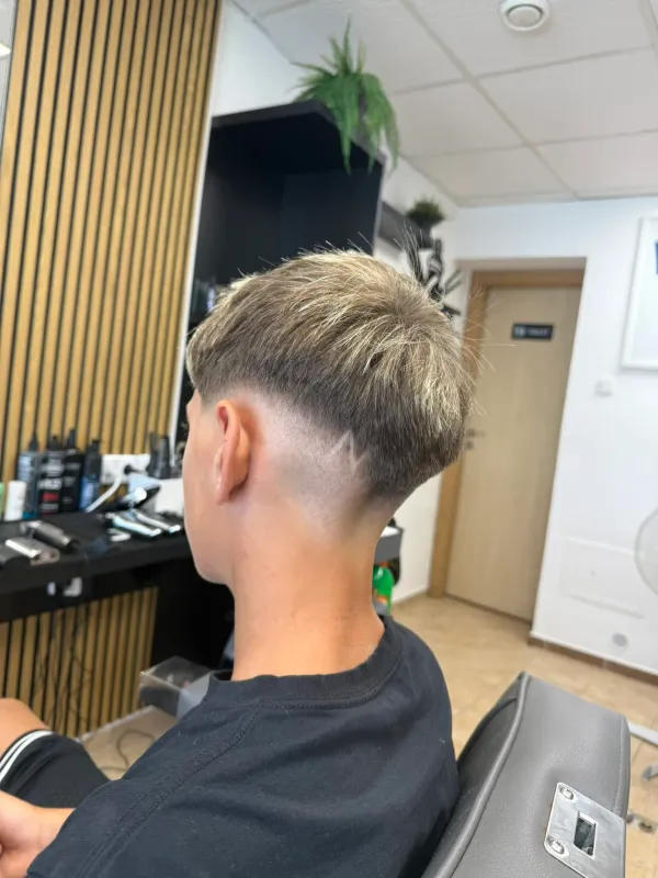 Dětský střih s výrazně vyholenou linkou (hair design) v Ori's Barber Shop.